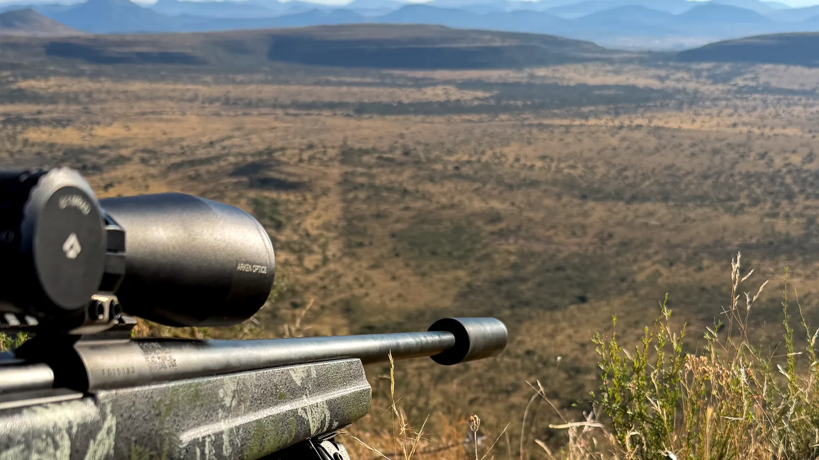 Scoped hunting rifle positioned above open Eastern Cape terrain