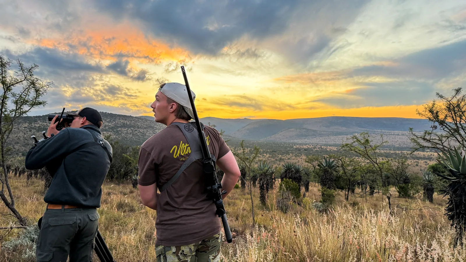 Hunters glassing wooded slopes and valleys in the Eastern Cape at sunset